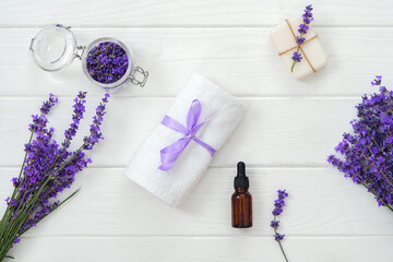 Obraz na płótnie Canvas Lavender soap bars and spa products with lavender flowers on a white wooden table