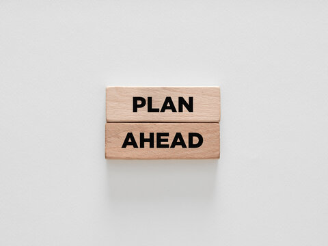 The words plan ahead on wooden blocks on white background.