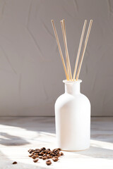 Aromatic reed diffuser with coffee beans on a white background