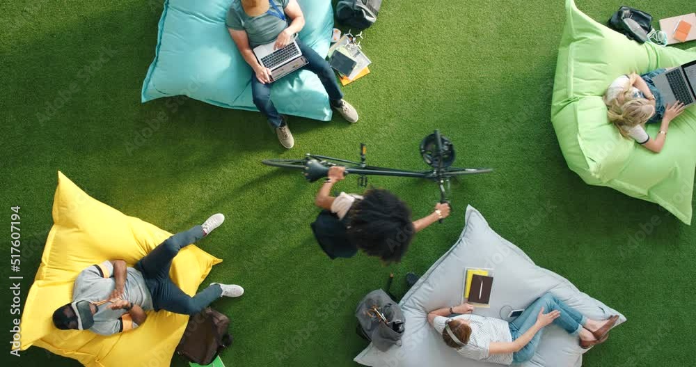 Poster Group of diverse students using technology sitting on beanbags in a library from above. Bright informal office space to improve creativity. Colorful spot for staff to relax and browse the internet