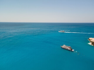 Fototapeta premium aerial view of porto katsiki beach with cruise boat people having fun