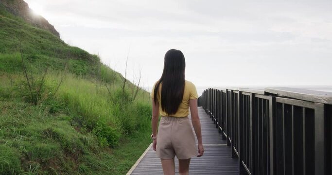 Woman walk on the wooden path