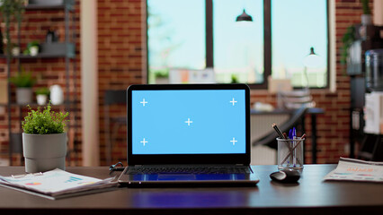 No people in empty office with greenscreen display on laptop, isolated copyspace template on modern computer. Blank chroma key background with mockup screen on pc network at desk.