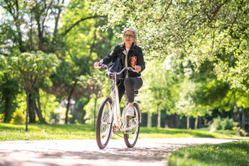 Fototapeta na wymiar A woman in black jacket on a bike