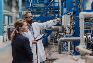 Engineering managers with tablet doing routine check up in industrial factory