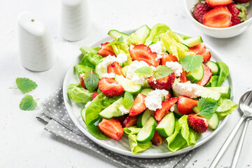Low calorie healthy strawberry cucumber feta cheese salad. Top view, copy space, flat lay.
