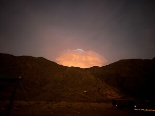 Obraz premium Bright thunderstorm clouds over the mountains in a dark sky