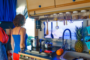 Woman inside Caravan, kitchen area