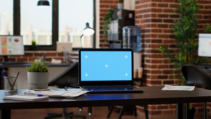 No people in empty startup office with greenscreen on laptop, chroma key background application on display. Computer with isolated mockup template and blank copyspace screen on desk.