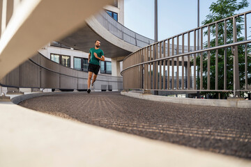Young man jogging on elevated walkway