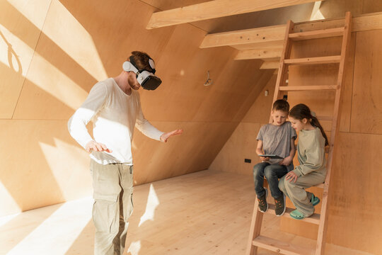 Man with 3d glasses and kids visualising home interior at new eco house