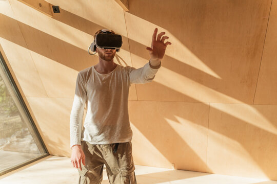 Man using 3d glasses to visualise home interior at of wooden eco house