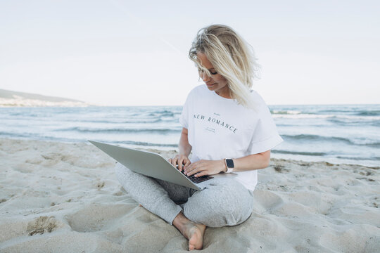 Happy Woman Using Laptop On Beach