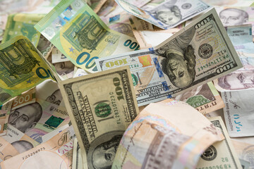 A lot of different money hryvnia euro and dollar bills on desk. exchange or saving concept