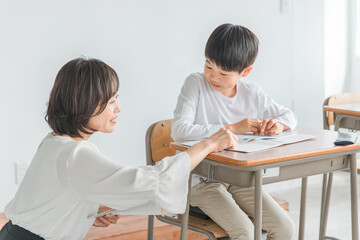 勉強する子供と指導する先生（夏期講習・個別指導）
