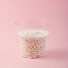 Disposable plastic cup with tapioca pearl on pink background. White sago pearls. Tapioca ball for...