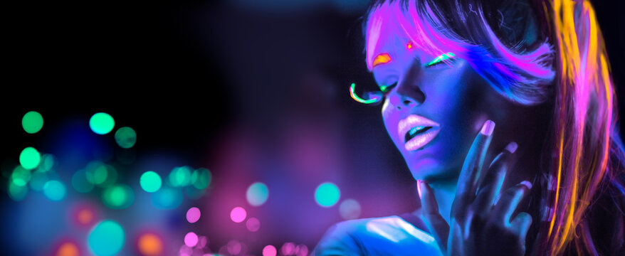Neon Woman dancing. Fashion model girl in neon light, portrait of beautiful model with fluorescent make-up, Night club. Disco dancer posing in UV, colorful make up. On bright background 