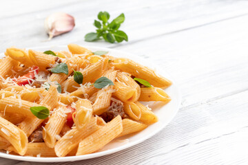Baked pasta with meat, tomatoes, basil leaves and red pepper. Top view with copy space
