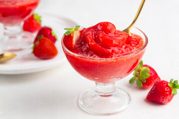Strawberry granita Siciliana, a semi-frozen dessert, fruit sorbet on a white background.
