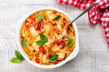 Pasta alla sorrentina.  Spiral shape fusilli pasta oven baked in casserole with tomato sauce, basil...