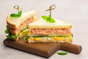 Keuken spatwand met foto Two Tuna sandwich with boiled egg, mayonnaise, lettuce on a wooden board. © Olga