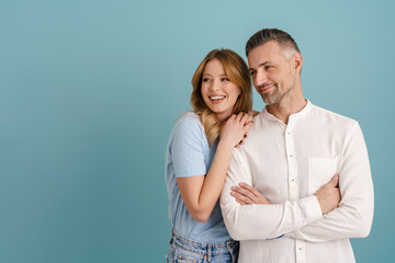 White happy couple hugging and smiling while looking aside