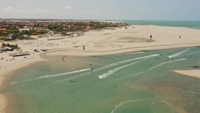Several kite surfers sail and play together in isolated pond on Brazilian beach