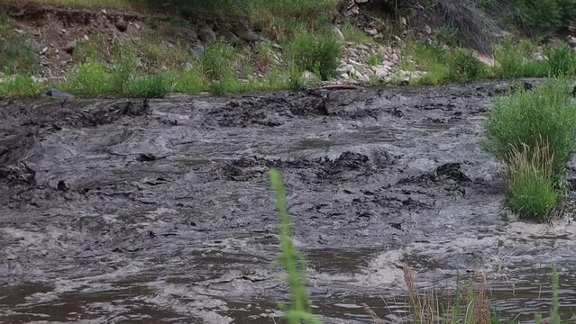 Burn scar and mud slide into the river near Glen Haven Colorado July 15, 2022.  This turns the river into a chocolate black mudflow.