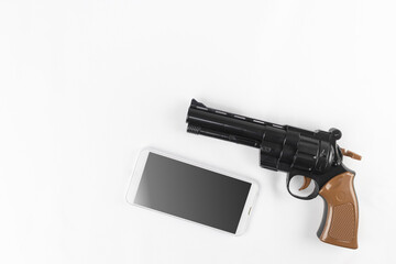 玩具の銃と、スマートフォン。犯罪予告のイメージ