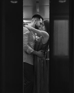 Young stylish caucasian couple hugging and kissing in hotels elevator