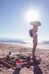 mom and son play at the beach making a sand castle together accomplices and happy