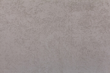 Fototapeta premium A plaster wall texture. A concrete wall painted in pale pink color. Abstract background.