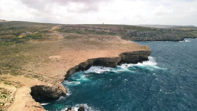 Aerial shot of sea waves crashing over the Popeye cliff of Malta. Set of Popeye Village, Malta
