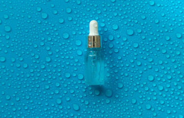 Bottle of cosmetics and drops of liquid, moisturizing. Hyaluronic acid. Selective focus.