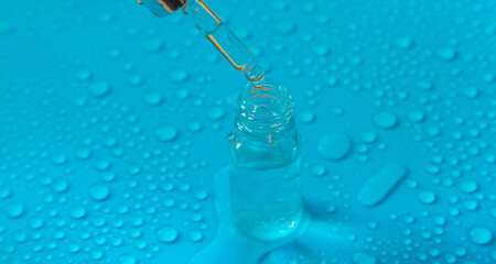 Bottle of cosmetics and drops of liquid, moisturizing. Hyaluronic acid. Selective focus.