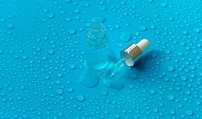 Bottle of cosmetics and drops of liquid, moisturizing. Hyaluronic acid. Selective focus.