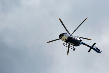 Fototapeta na wymiar Police rescue helicopter on a background of cloudy sky.