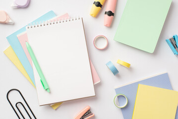 Back to school concept. Top view photo of notebooks pen mini staplers adhesive tape round correction tape and markers on isolated white background with blank space