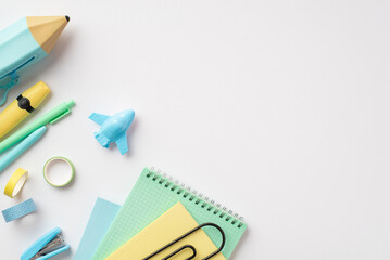 Back to school concept. Top view photo of school accessories blue pencil-case plane shaped sharpener notepads adhesive tape mini stapler marker and pens on isolated white background with empty space