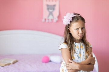 A girl of eight years old, offended. Portrait in the room