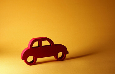 red wooden toy car on yellow background
