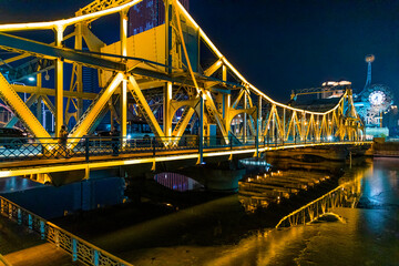 Fototapeta na wymiar Bridge over river at night in Tianjin city