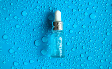 Bottle of cosmetics and drops of liquid, moisturizing. Hyaluronic acid. Selective focus.