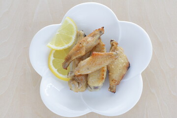 Chinese food, pan fried chicken wings served with lemon for comfort food image