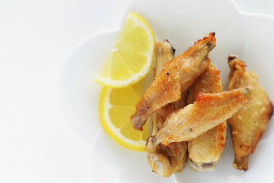 Chinese food, pan fried chicken wings served with lemon for comfort food image