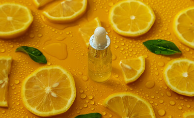 Bottle of cosmetics and drops of liquid, moisturizing lemon. Hyaluronic acid. Selective focus.