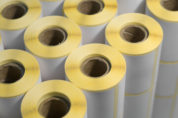 Rollers with a white self-adhesive label for printing labeling information. Ribbon with white label...