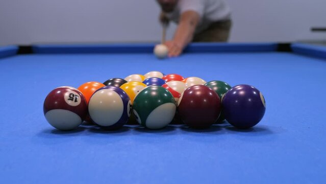 A man strikes the balls in American billiards. Sports game in slow motion
