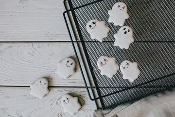 Funny scary Halloween ghost cookies with white icing on black tray. - obrazy, fototapety, plakaty