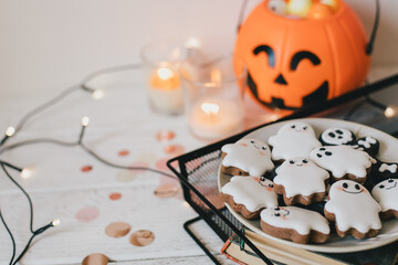 Funny scary Halloween ghost cookies on white wooden background.